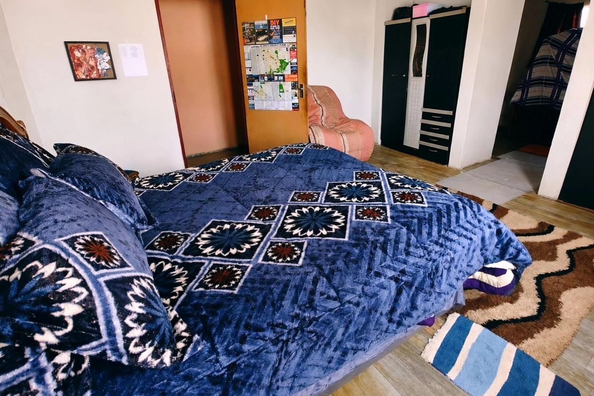 A bedroom featuring laminate flooring and a standard internal door, providing a functional living space.