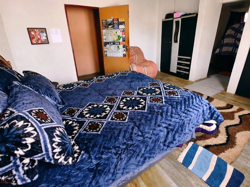 A bedroom featuring laminate flooring and a standard internal door, providing a functional living space.