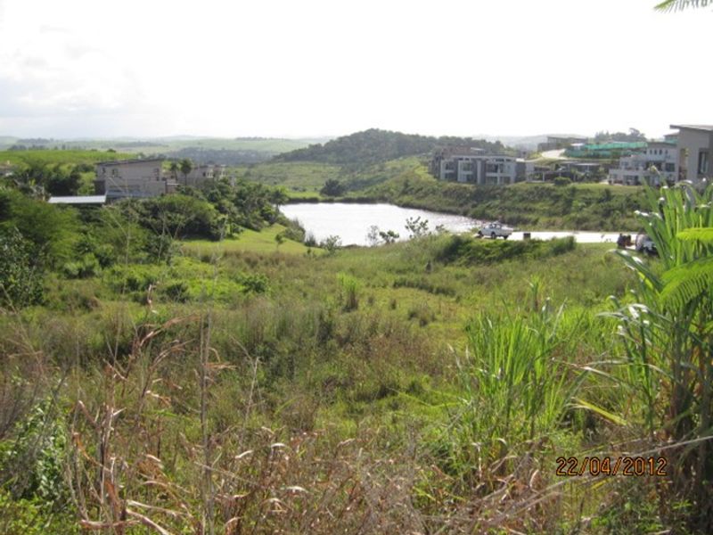 A scenic view of the surrounding landscape featuring natural vegetation and a nearby water body within a residential estate setting.