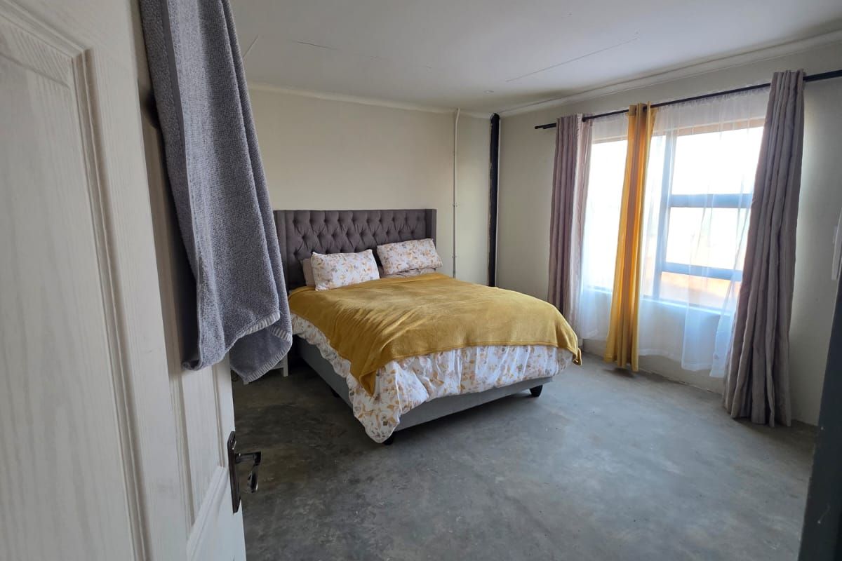 A bedroom featuring unfinished concrete flooring and recessed ceiling lighting, offering a blank canvas for potential flooring upgrades and interior finishes.