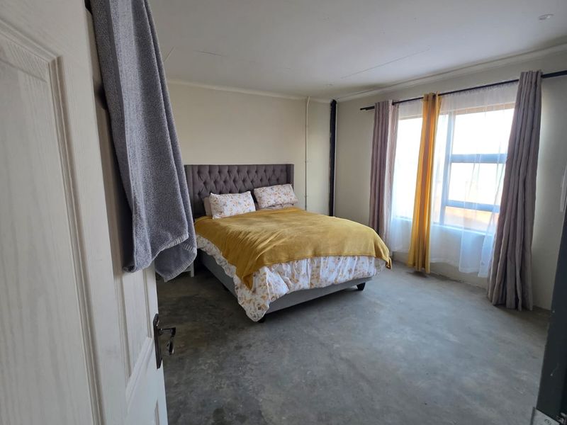 A bedroom featuring unfinished concrete flooring and recessed ceiling lighting, offering a blank canvas for potential flooring upgrades and interior finishes.