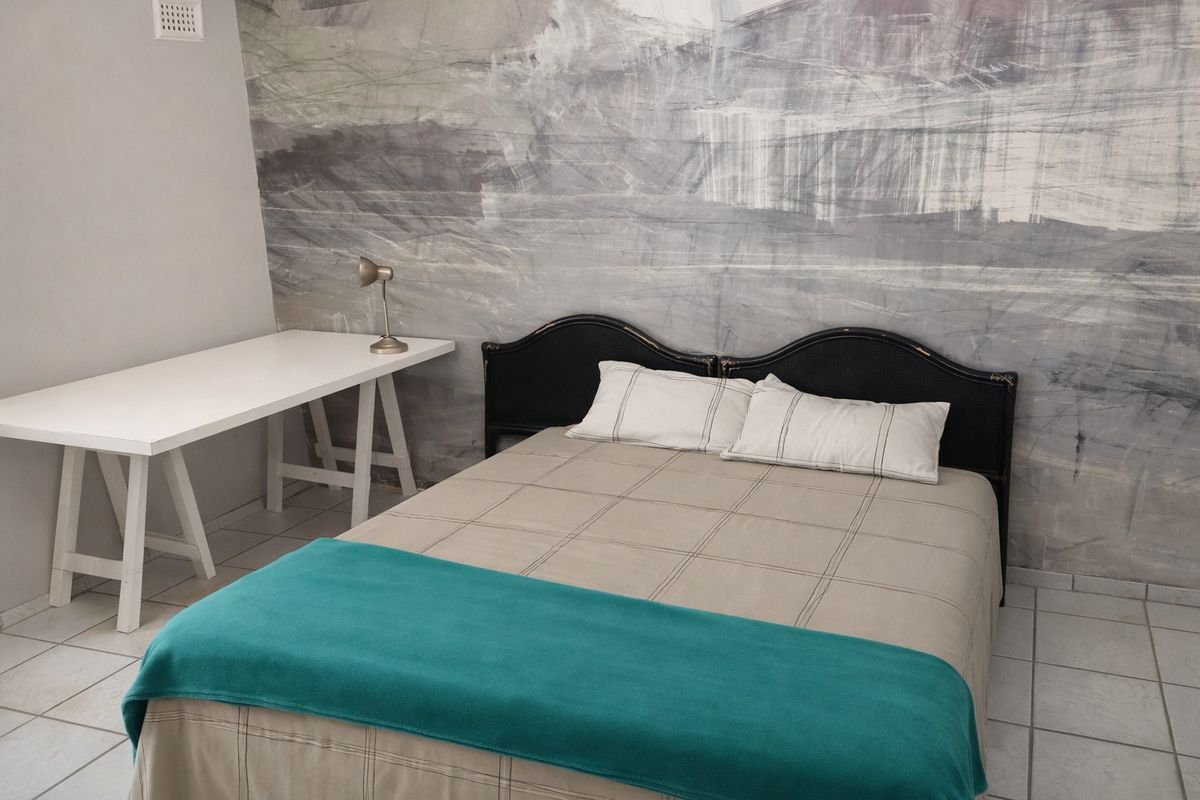 A bedroom featuring tiled flooring and a decorative textured feature wall.
