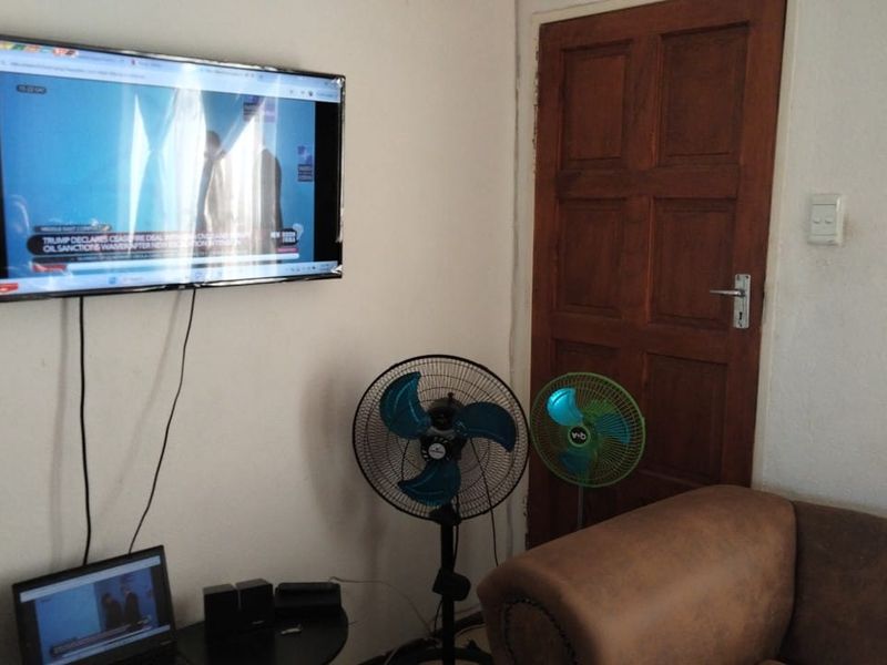 A living room area featuring a wall-mounted television and a traditional wooden door.