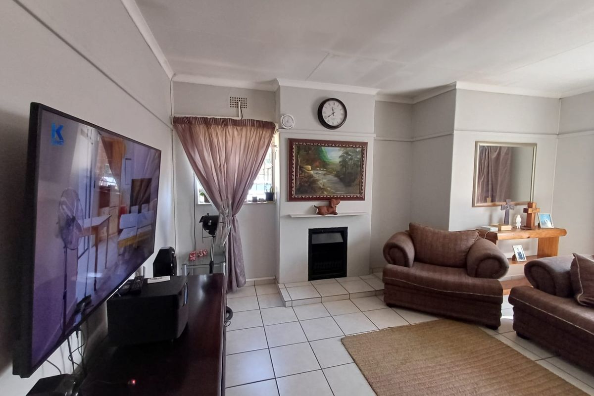 A living room featuring tiled flooring, a built-in fireplace, and traditional coved ceilings with picture rails.