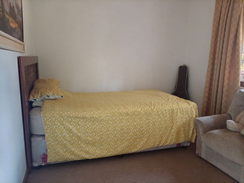 A standard bedroom featuring neutral wall finishes and carpeted flooring, providing a functional and comfortable living space within the retirement village.