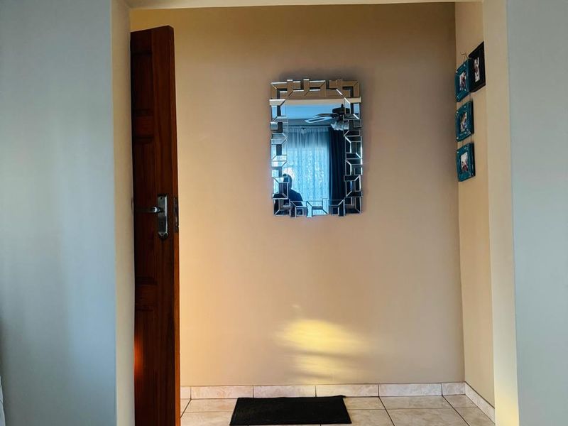 A bright and simple entryway featuring tiled flooring and neutral wall tones, providing a clean and welcoming transition space.