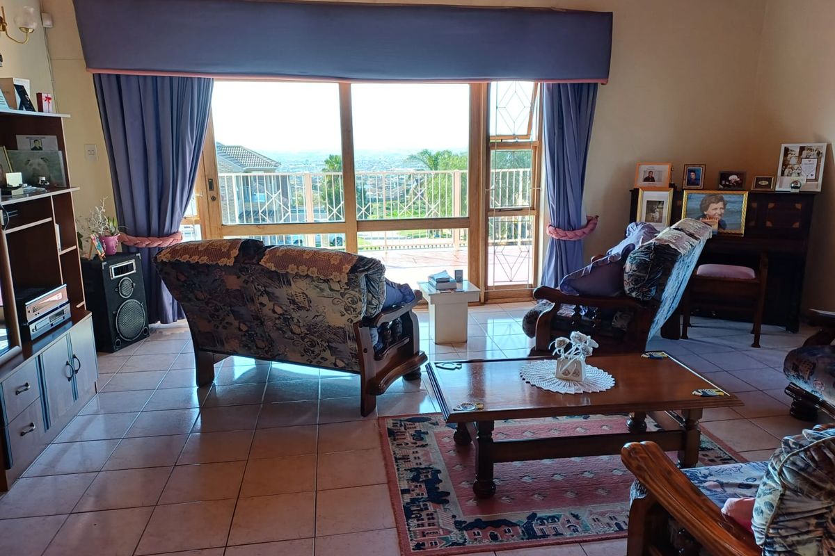 A spacious living room featuring tiled flooring and large sliding glass doors that provide natural light and access to an outdoor area.