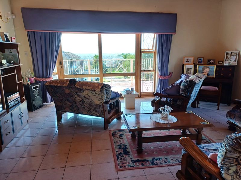 A spacious living room featuring tiled flooring and large sliding glass doors that provide natural light and access to an outdoor area.