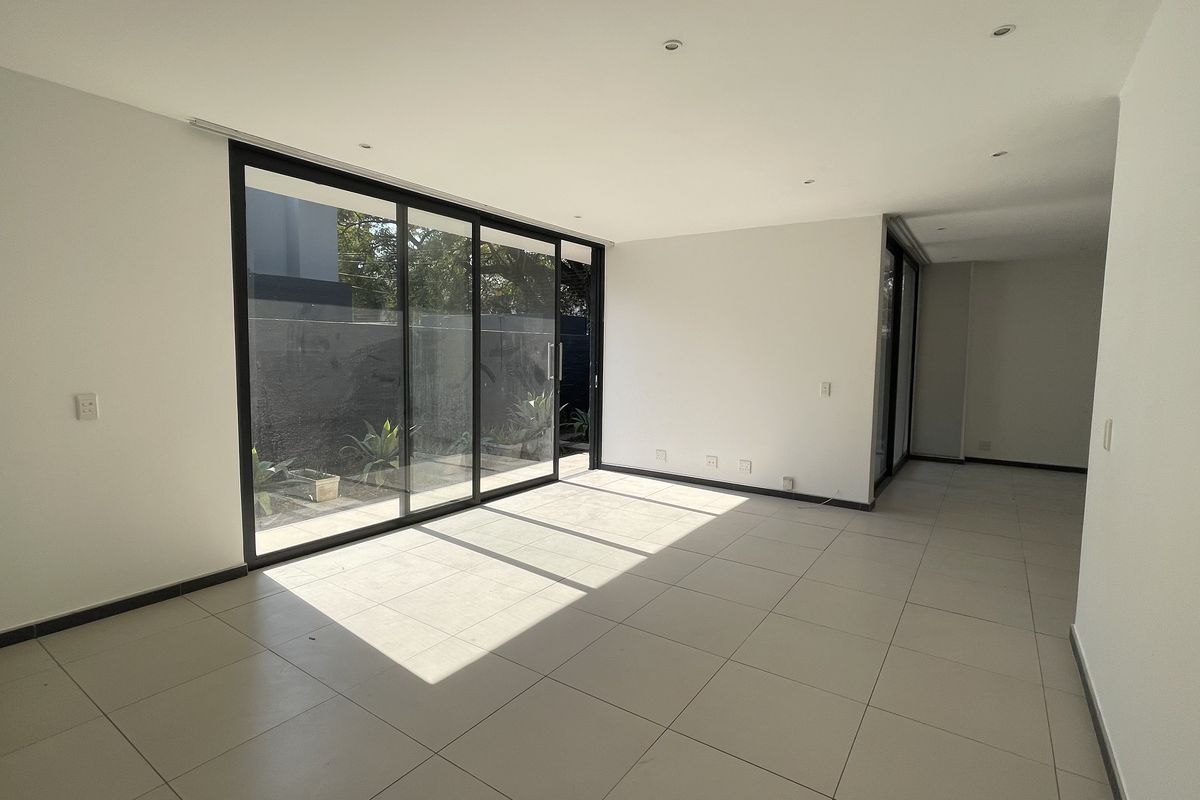 A bright, open-plan living area featuring large sliding glass doors that provide ample natural light and direct access to the outdoor space.