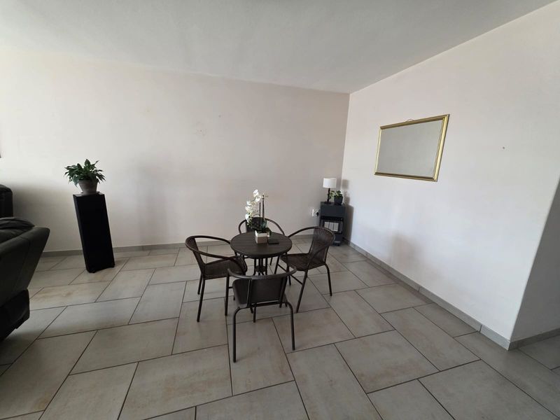 A spacious living area featuring neutral wall finishes and large format floor tiles, providing a clean and versatile foundation for interior design.