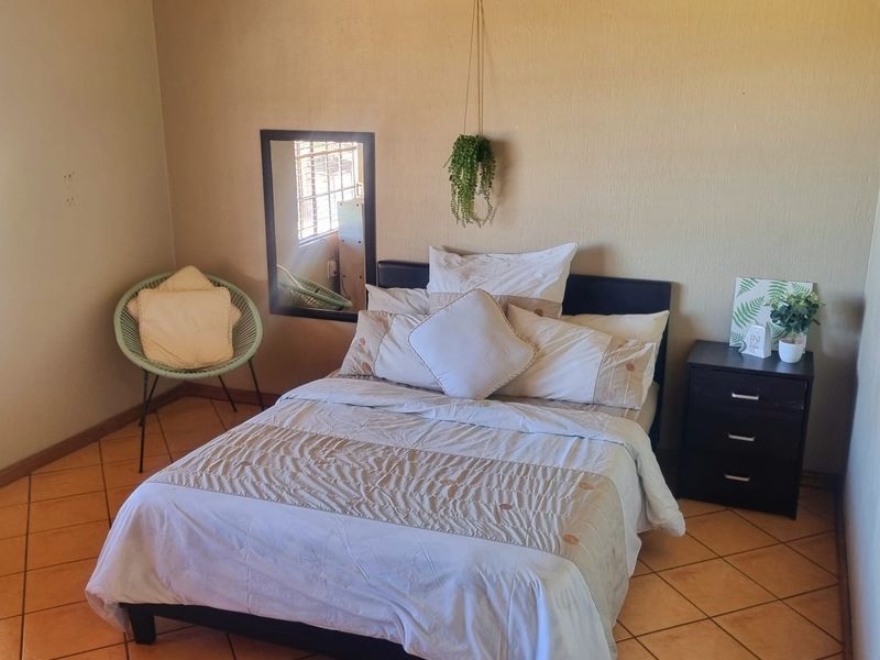 A bedroom featuring ceramic floor tiles and textured wall finishes, providing a functional space ready for cosmetic updates.