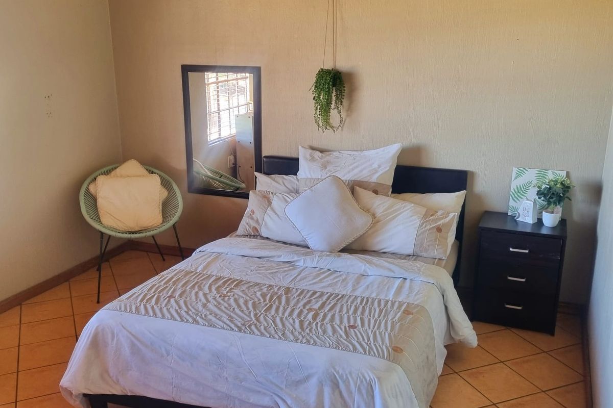 A bedroom featuring ceramic floor tiles and textured wall finishes, providing a functional space ready for cosmetic updates.