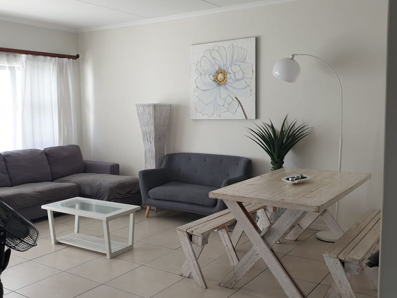 An open-plan living and dining area featuring neutral tiled flooring and a bright, functional layout suitable for modern living.
