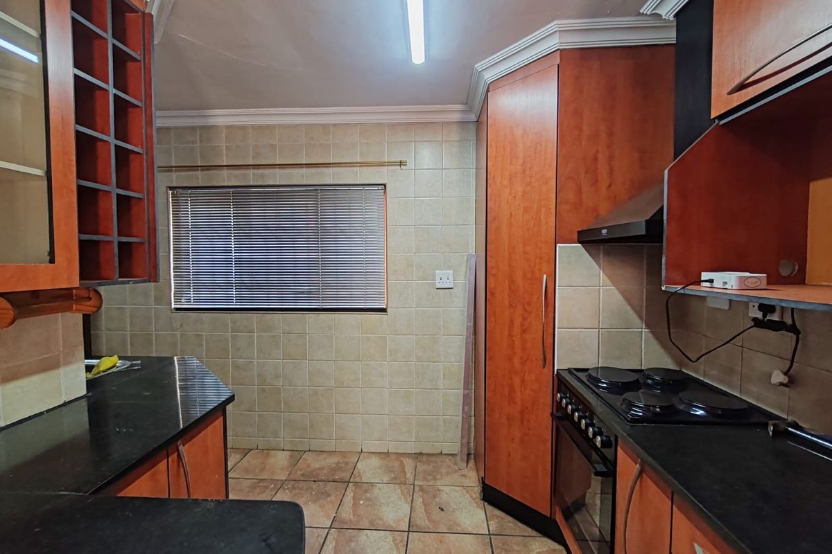 A functional kitchen featuring wooden cabinetry, granite countertops, and built-in cooking appliances, offering a solid foundation for a modern renovation.