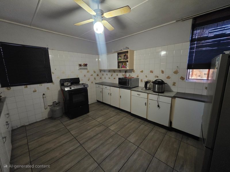 A functional kitchen featuring tiled flooring, a gas stove, and ample built-in cabinetry with a tiled splashback.