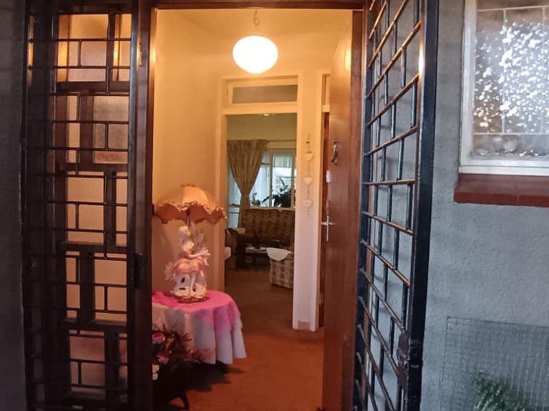 View of the property entrance featuring a security gate and a glimpse into the interior living space.