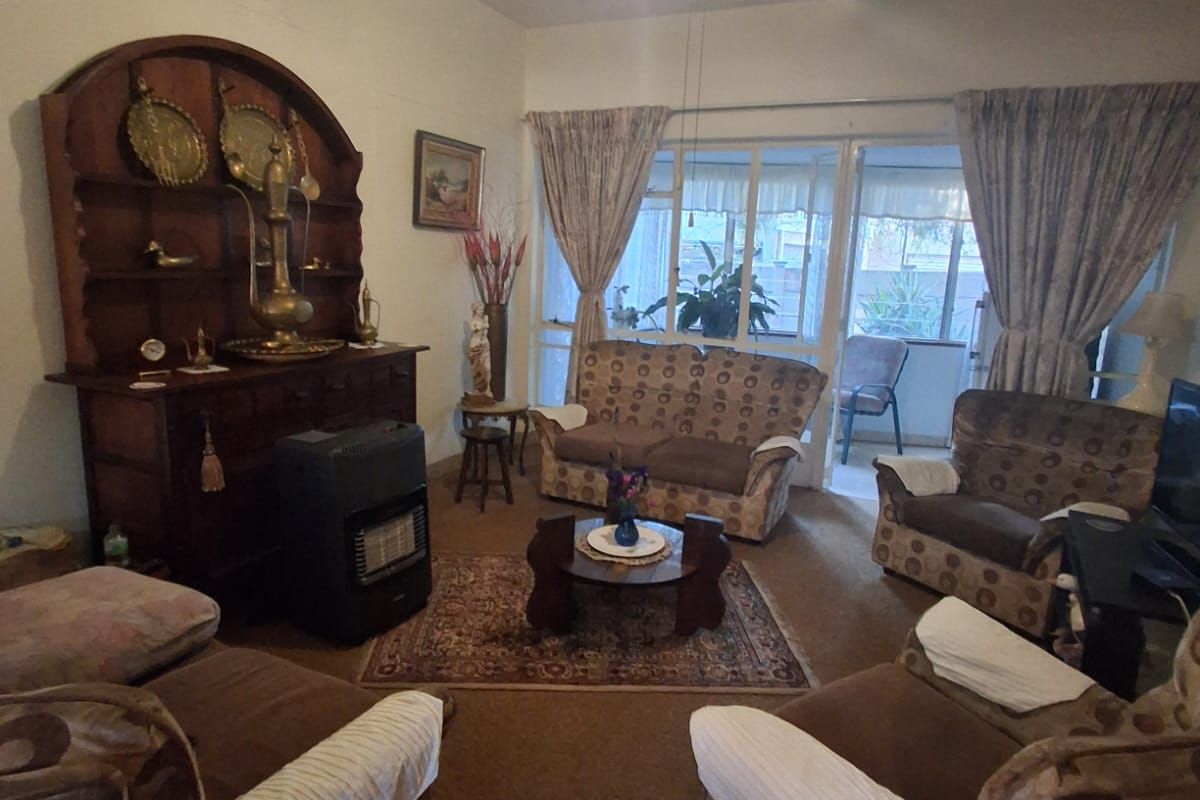 A living room featuring carpet flooring, a ceiling fan, and a sliding glass door providing access to an outdoor area.