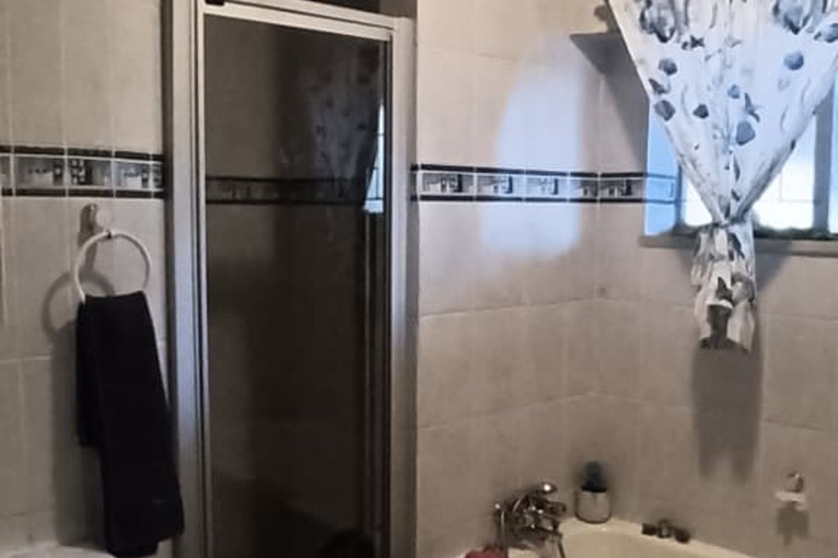 A functional bathroom featuring a built-in vanity, a separate shower enclosure, and a bathtub with tiled wall finishes.