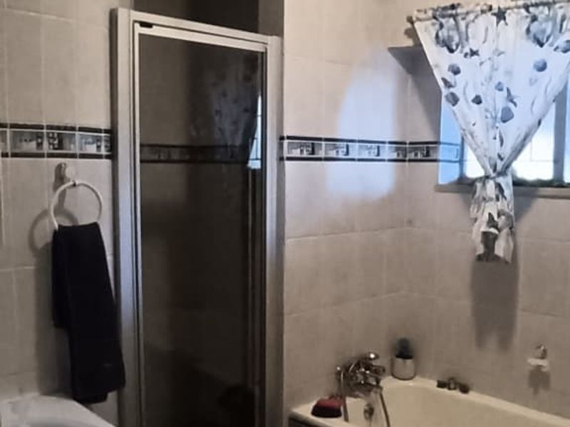 A functional bathroom featuring a built-in vanity, a separate shower enclosure, and a bathtub with tiled wall finishes.