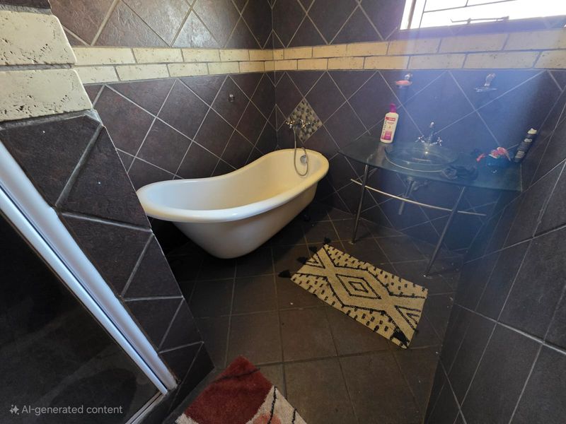 A bathroom featuring a freestanding bathtub, a glass vessel sink with a metal stand, and dark ceramic wall and floor tiling.