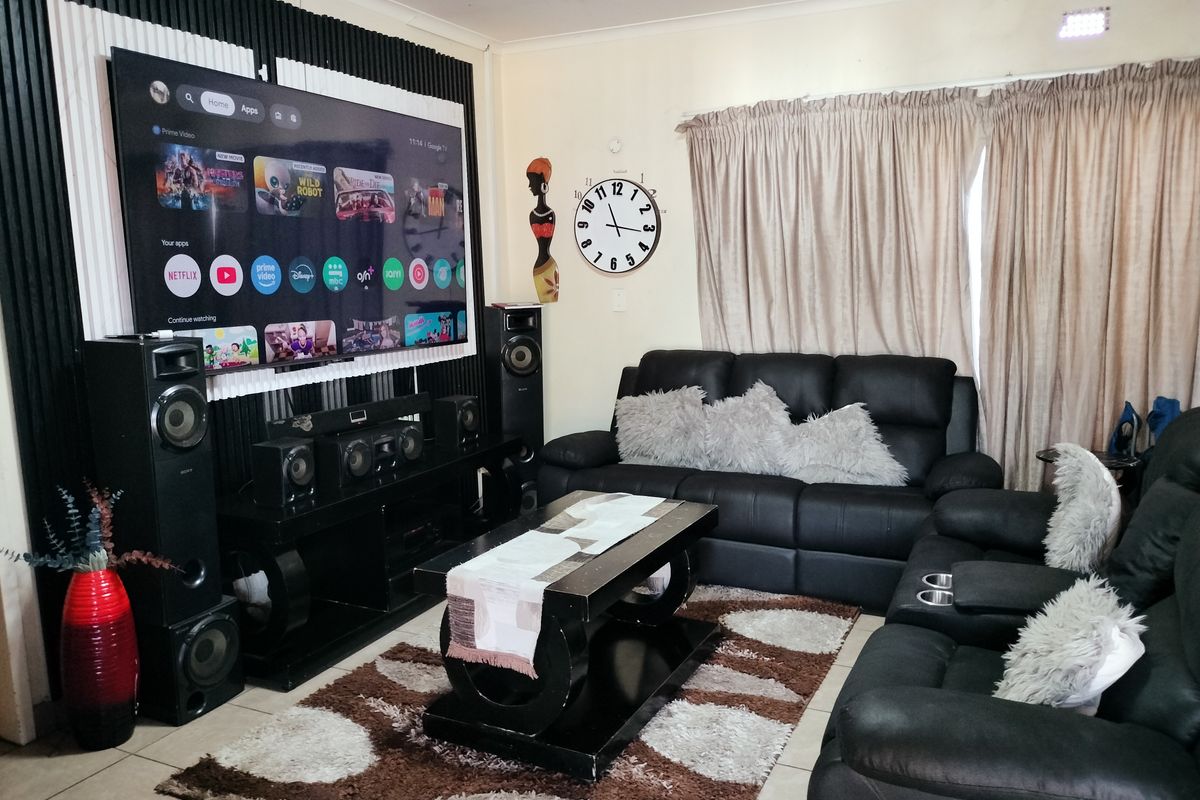A living room featuring a decorative feature wall and tiled flooring, providing a functional space for relaxation and entertainment.