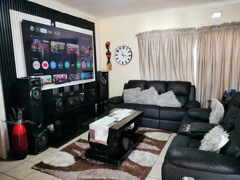 A living room featuring a decorative feature wall and tiled flooring, providing a functional space for relaxation and entertainment.