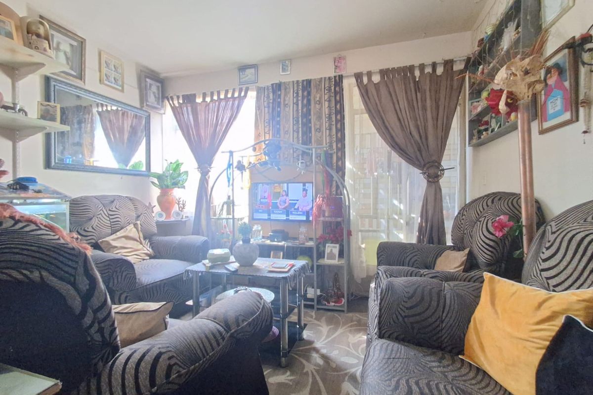A living room area featuring a sliding glass door and significant ceiling damage requiring repair.