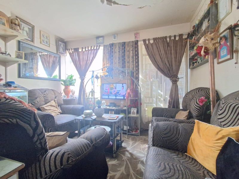 A living room area featuring a sliding glass door and significant ceiling damage requiring repair.