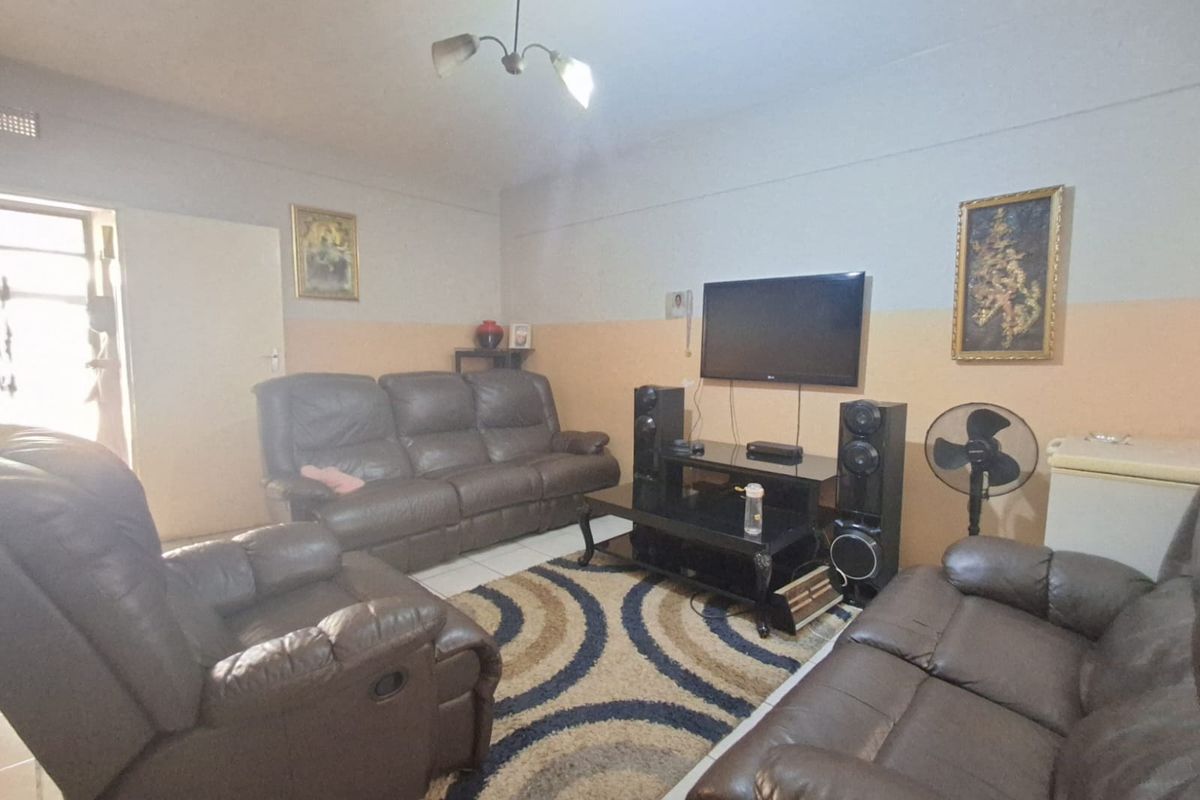 A living room area featuring tiled flooring and neutral wall finishes, providing a functional space for relaxation.