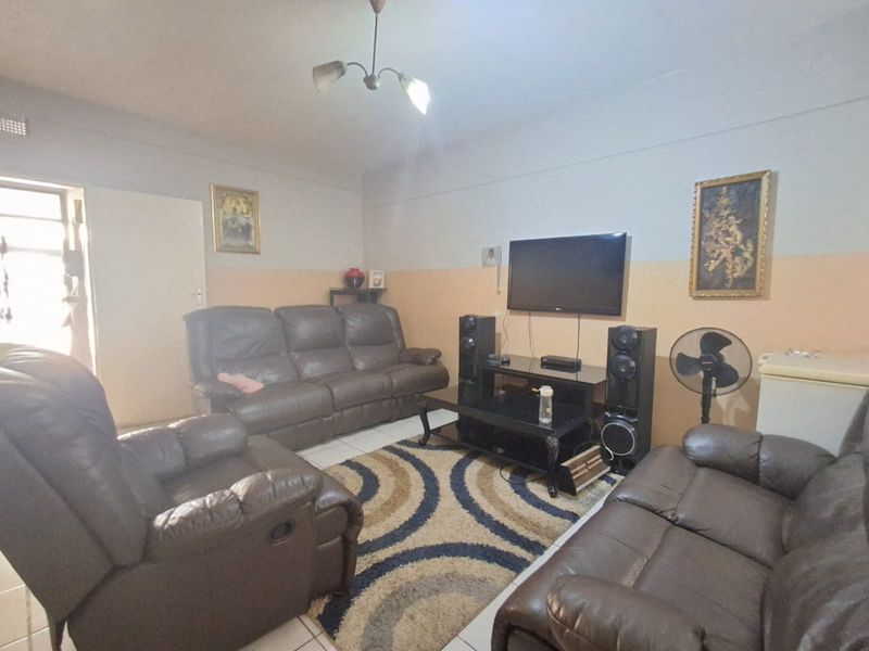 A living room area featuring tiled flooring and neutral wall finishes, providing a functional space for relaxation.