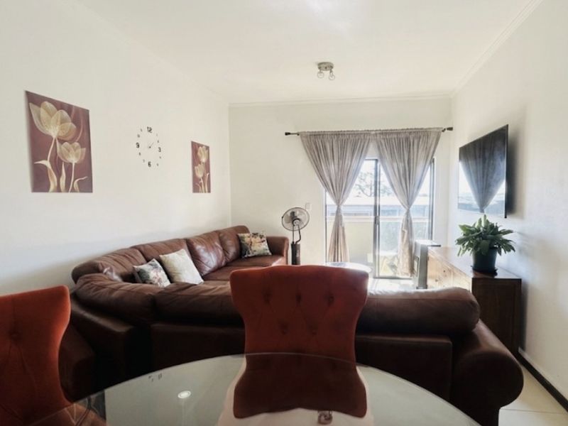 Open-plan living and dining area featuring tiled flooring and a sliding glass door leading to an outdoor space.
