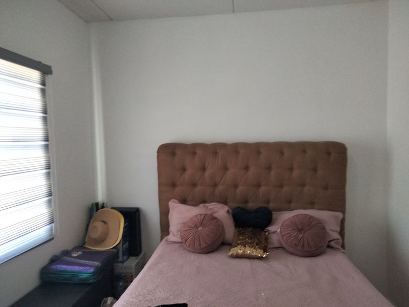 A bedroom featuring a neutral wall finish and a fitted roller blind on the window.