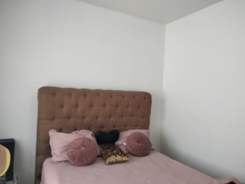 A simple bedroom space with plain white walls.