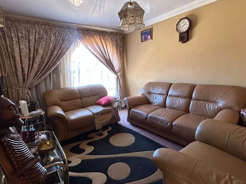 A comfortable living room featuring a glossy ceiling finish and decorative coving, providing a functional space for relaxation.