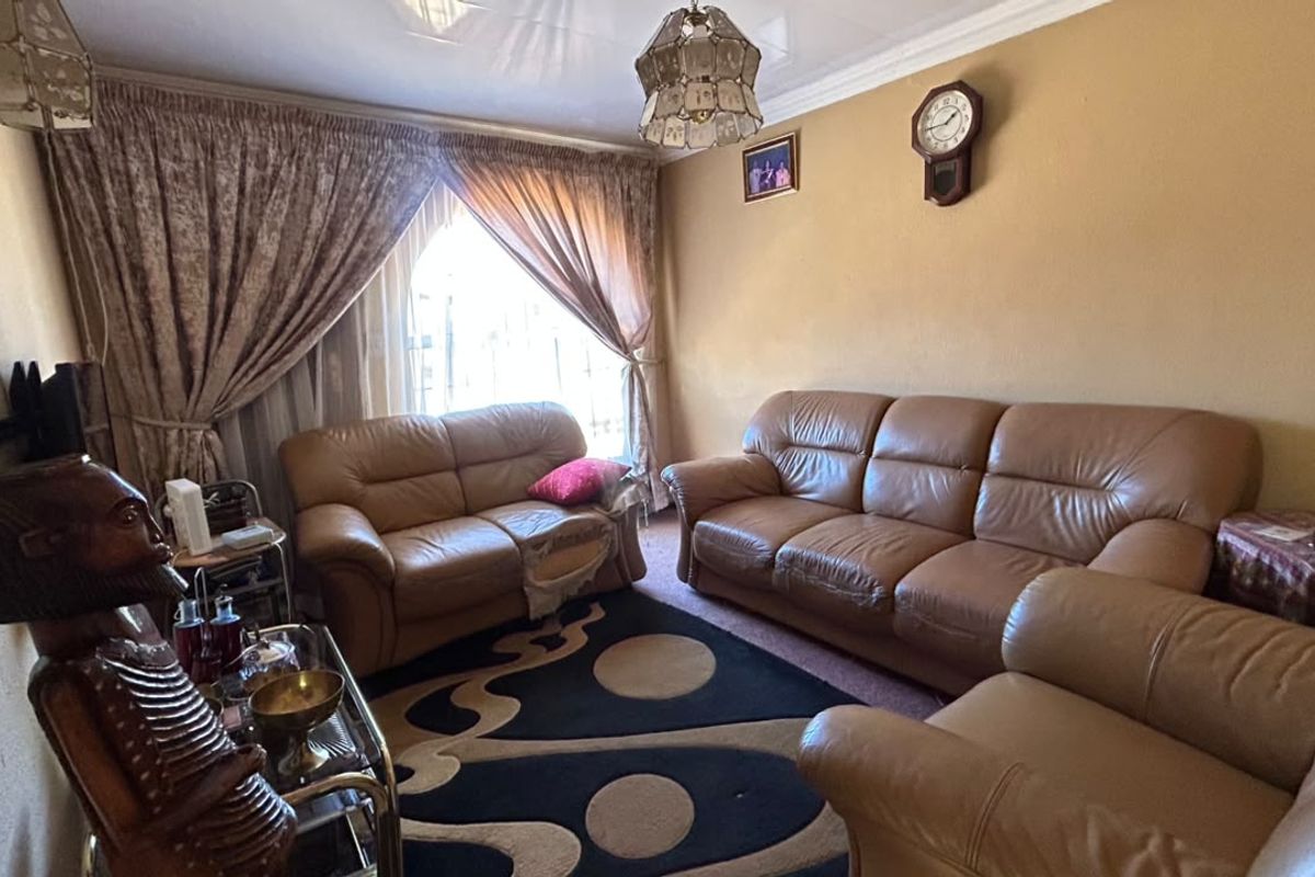 A comfortable living room featuring a glossy ceiling finish and decorative coving, providing a functional space for relaxation.