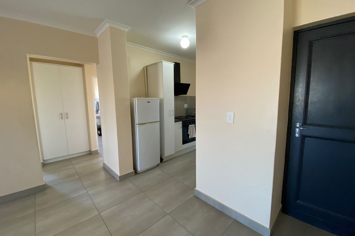 A functional kitchen area featuring tiled flooring, built-in cabinetry, and integrated cooking appliances, providing a clean and practical layout for daily use.