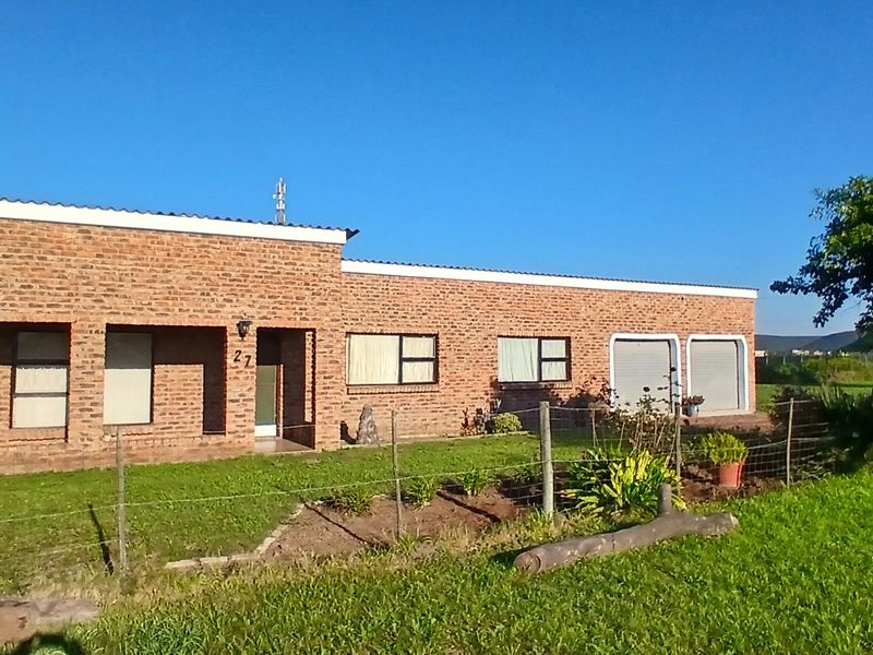A single-story face brick residential property featuring a double garage, covered entrance, and a spacious front garden area.