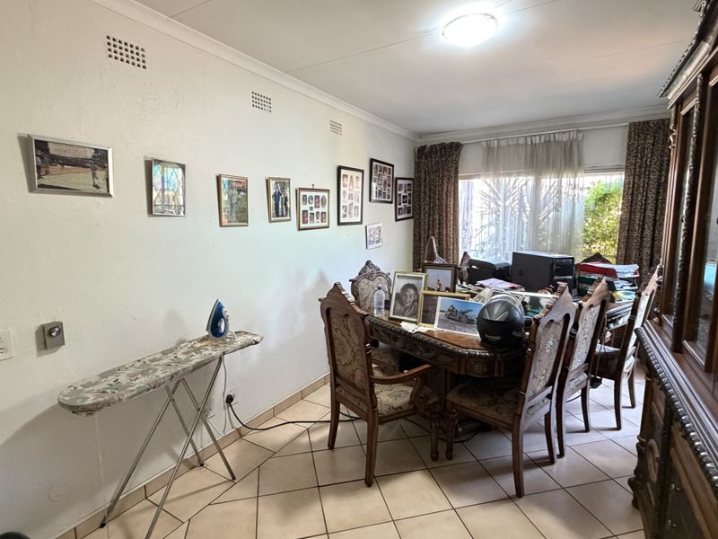 A dining room featuring tiled flooring, coved ceilings, and a sliding glass door providing natural light.