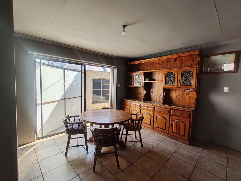 Dining area featuring tiled flooring, built-in wooden cabinetry, and a sliding glass door providing access to the exterior.