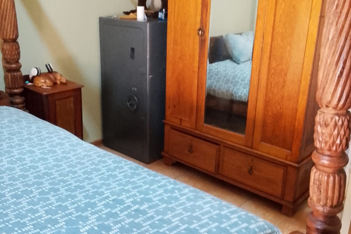 A bedroom featuring tiled flooring and neutral wall finishes, providing a functional space for rest.