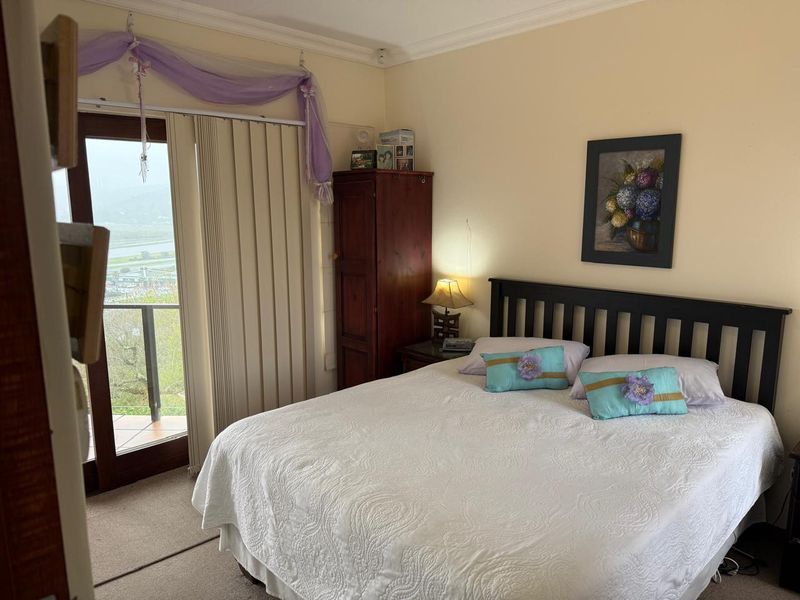 A bedroom featuring carpeted flooring and a sliding glass door providing access to an outdoor balcony area.