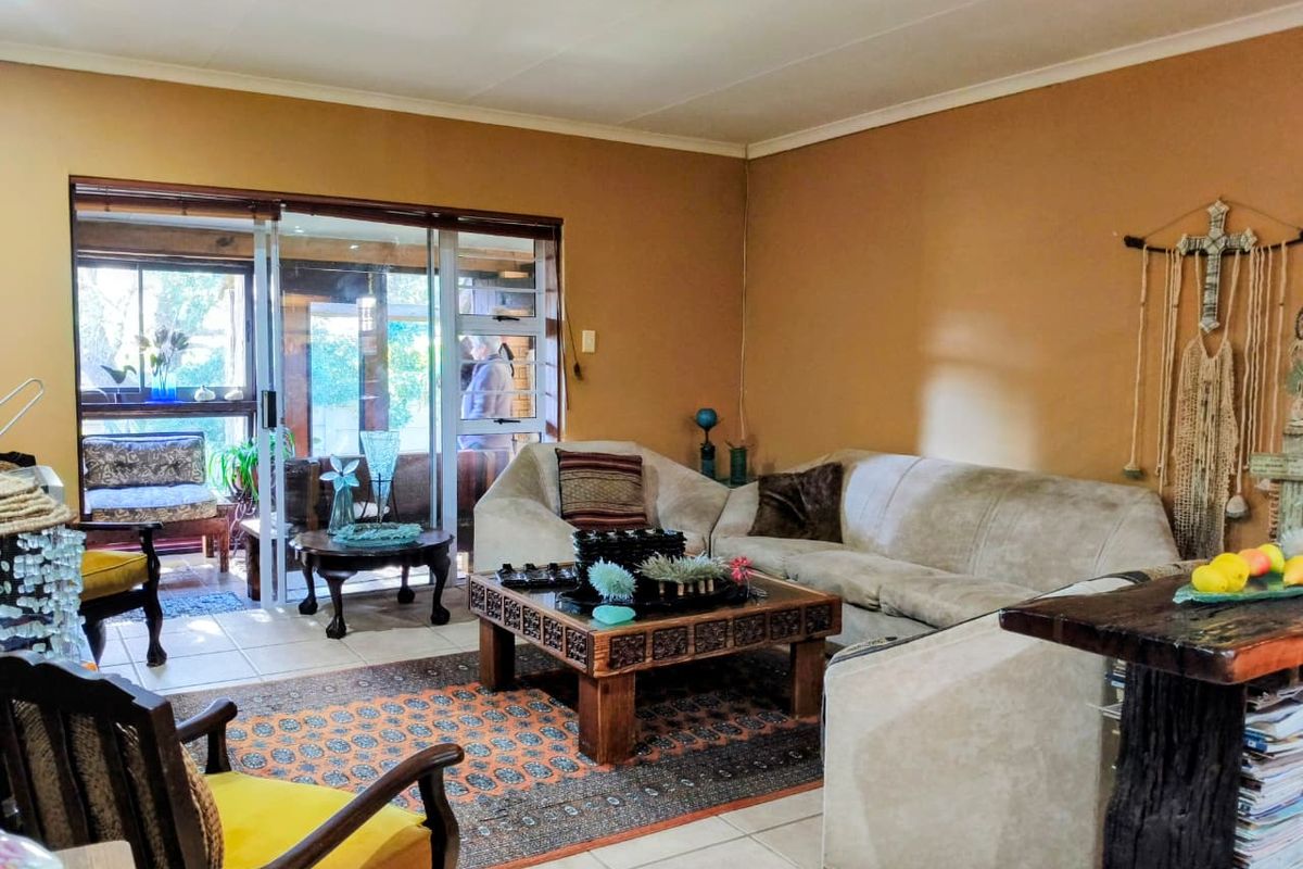 A living room featuring tiled flooring and a large sliding glass door providing access to an outdoor patio area.