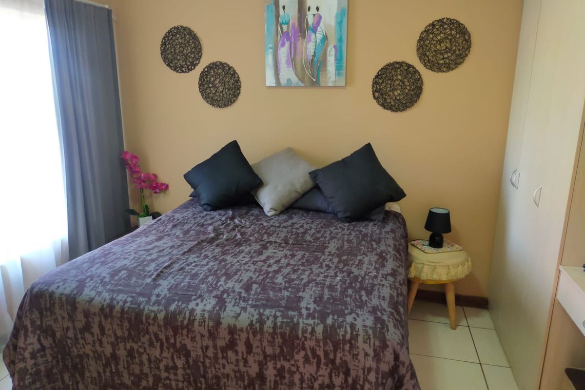 A bedroom featuring tiled flooring and a built-in wardrobe, providing functional storage space.