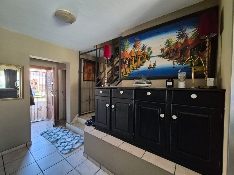 Entrance hall featuring tiled flooring, a wrought iron staircase railing, and a built-in raised platform area.
