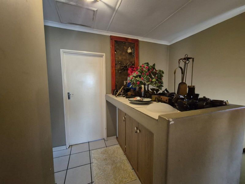 A built-in bar area featuring under-counter cabinetry and tiled flooring, offering a dedicated space for entertaining.