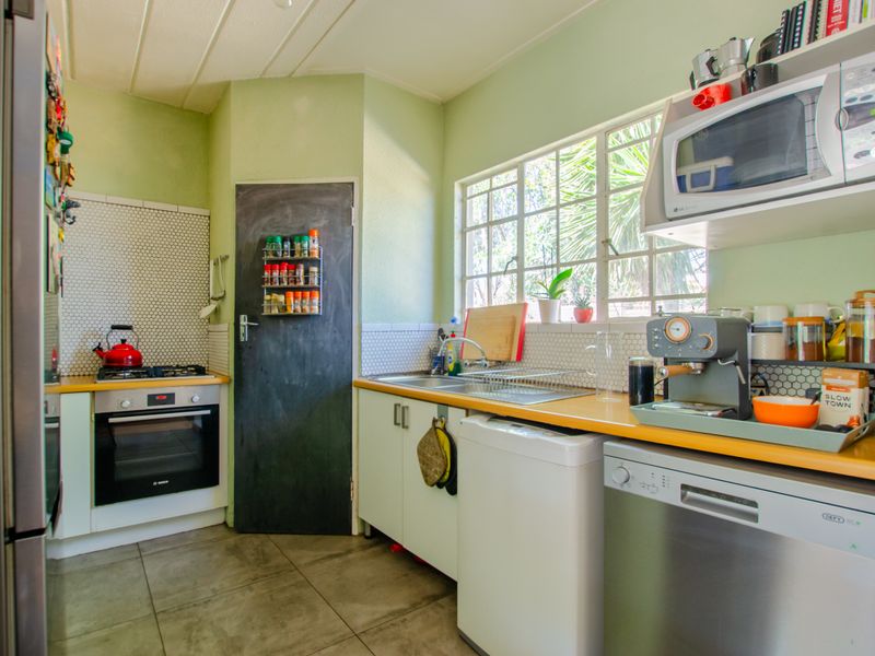 Functional kitchen featuring a built-in oven, gas hob, mosaic backsplash, and ample counter space with a bright, practical layout.