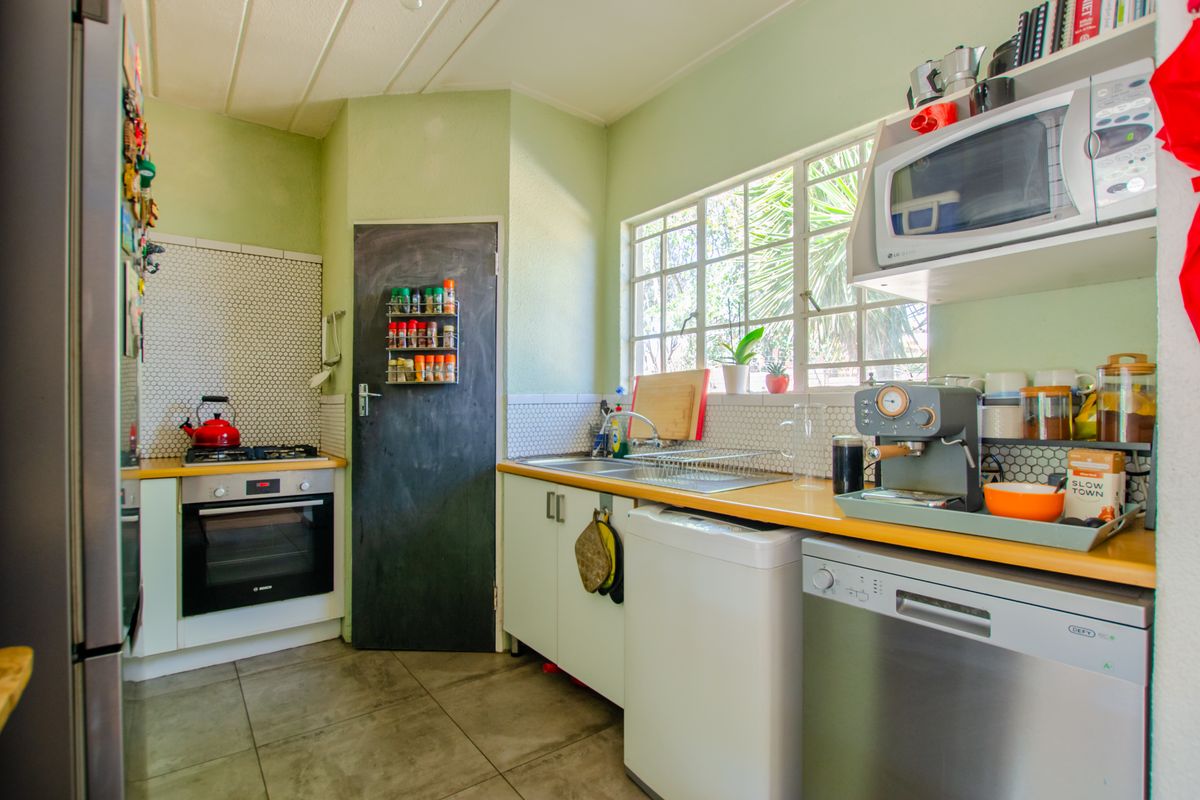 Functional kitchen featuring a built-in oven, gas hob, mosaic backsplash, and ample counter space with a bright, practical layout.