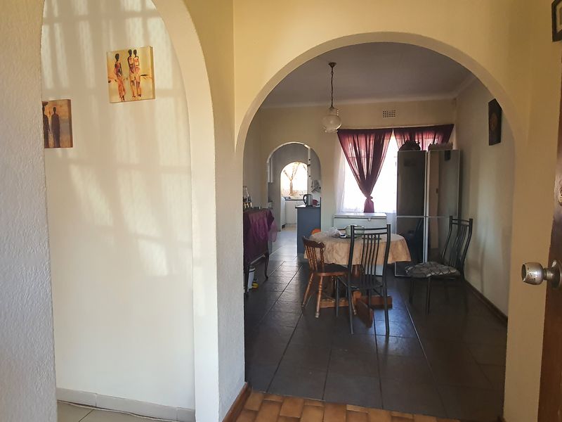Entryway featuring arched architectural details and tiled flooring, providing a transition into the open-plan living and dining area.