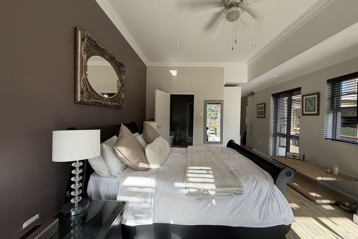 Spacious bedroom featuring neutral walls, crown molding, recessed lighting, a ceiling fan, and large windows with venetian blinds.
