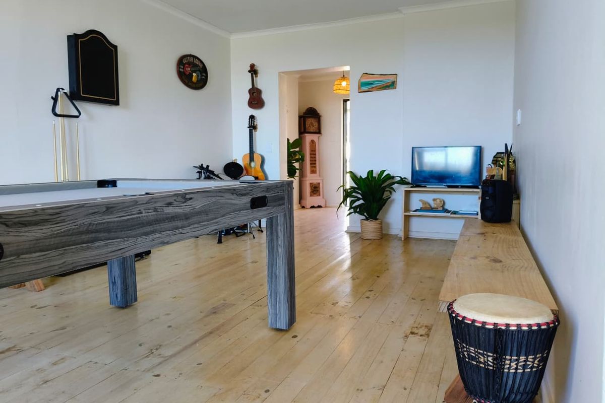 A spacious living area featuring polished timber flooring and neutral walls, providing a versatile space for relaxation or entertainment.